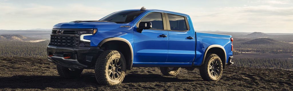 Blue Chevrolet Silverado parked on a rocky landscape.