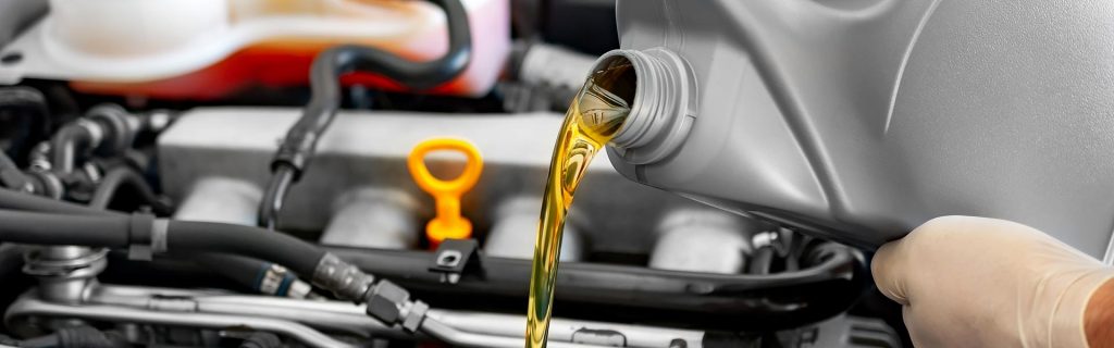 Pouring fresh motor oil into a car engine.